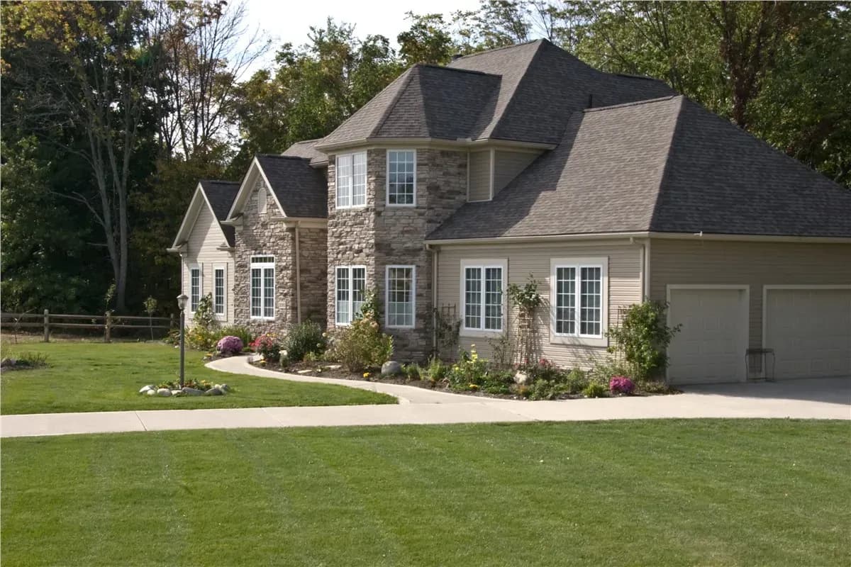 Side view of home with casement windows and stone siding